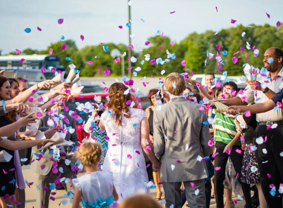 Wedding guests showering a couple in confetti