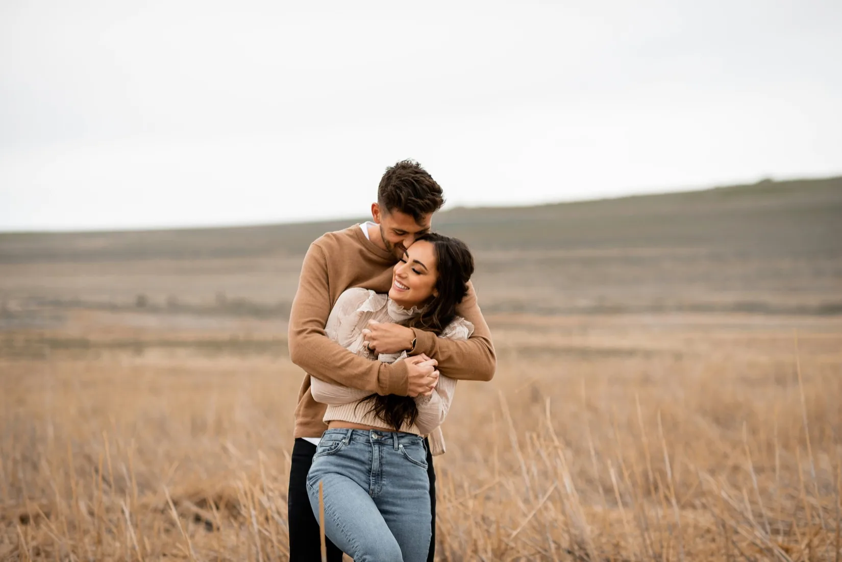 A couple laughing together in a field