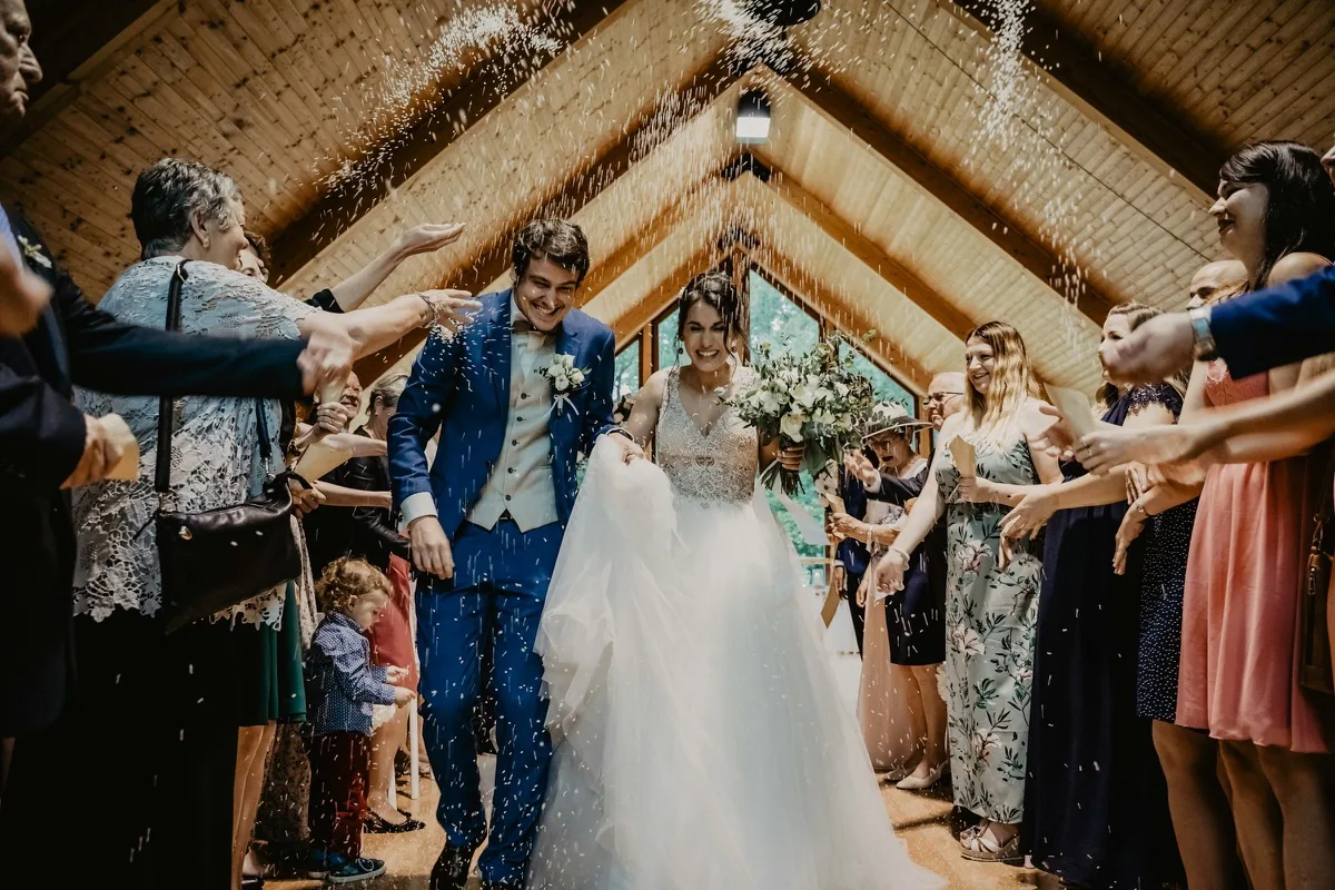 Guests throwing confetti over a couple leaving their wedding ceremony
